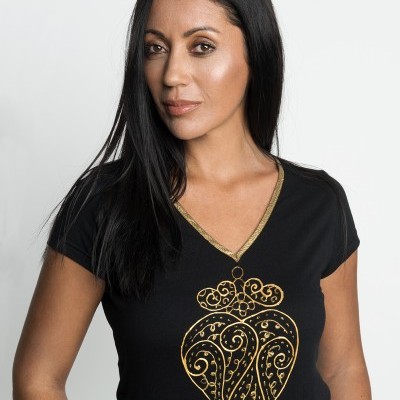 Mulher com t-shirt preta com desenho dourado decorativo em forma de coração