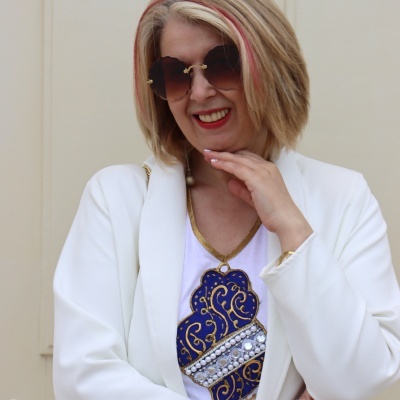 Senhora com óculos de sol em forma de coração e blazer branco