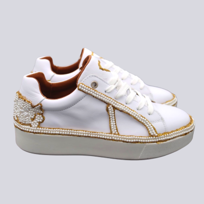 Ténis brancos com detalhes em pérolas douradas e brancas, sola espessa e interior castanho