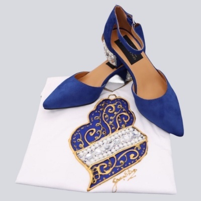 Sapatos azul royal com detalhe de pérolas sobre t-shirt branca bordada