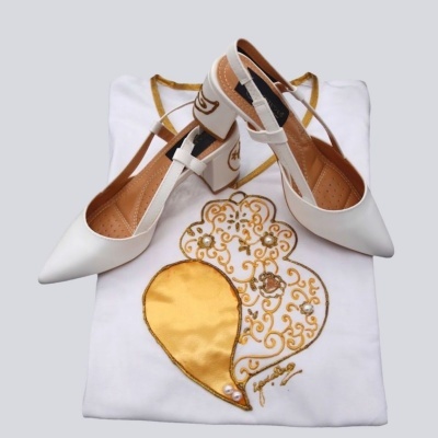 Sapatos brancos com detalhes bege e preto sobre roupa branca bordada