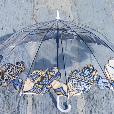 Guarda-chuva transparente com detalhes azuis, brancos e dourados na borda