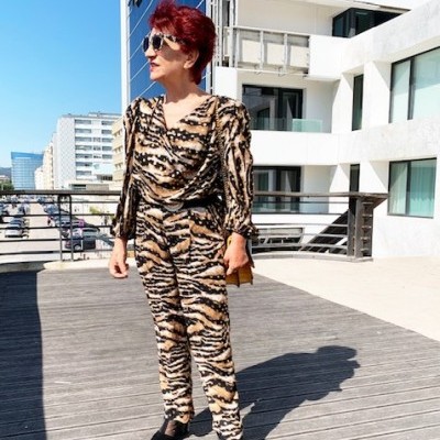 Mulher com fato animal print em ambiente urbano exterior
