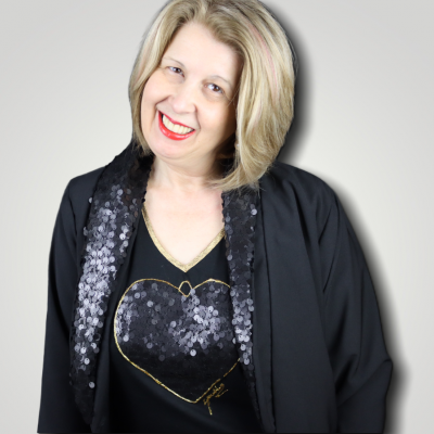 Mulher com camisola preta de coração de lantejoulas e casaco preto com gola de lantejoulas