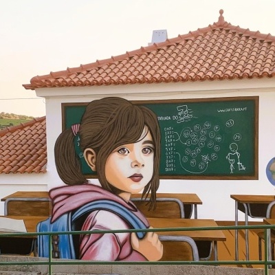 Mural pintado de rapariga numa sala de aula com carteira, quadro e globo