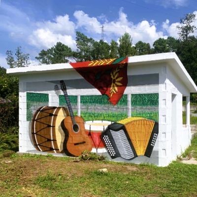 Mural de instrumentos musicais tradicionais pintado em parede branca ao ar livre.