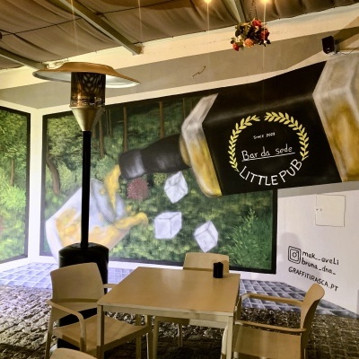 Mural de bar e zona exterior com mesa, cadeiras e aquecedor