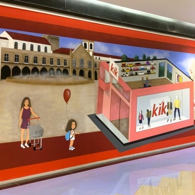Mural colorido com loja KiK, pessoas e edifícios antigos