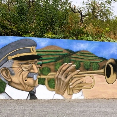 Mural de homem idoso tocando trompete com chapéu e camisa branca, colinas verdes ao fundo