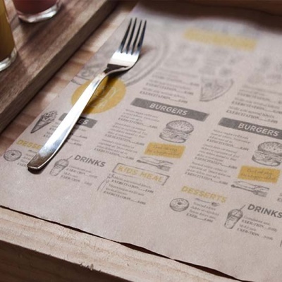 Menu de papel castanho com texto em preto e amarelo, garfo de metal em cima de bandeja de madeira