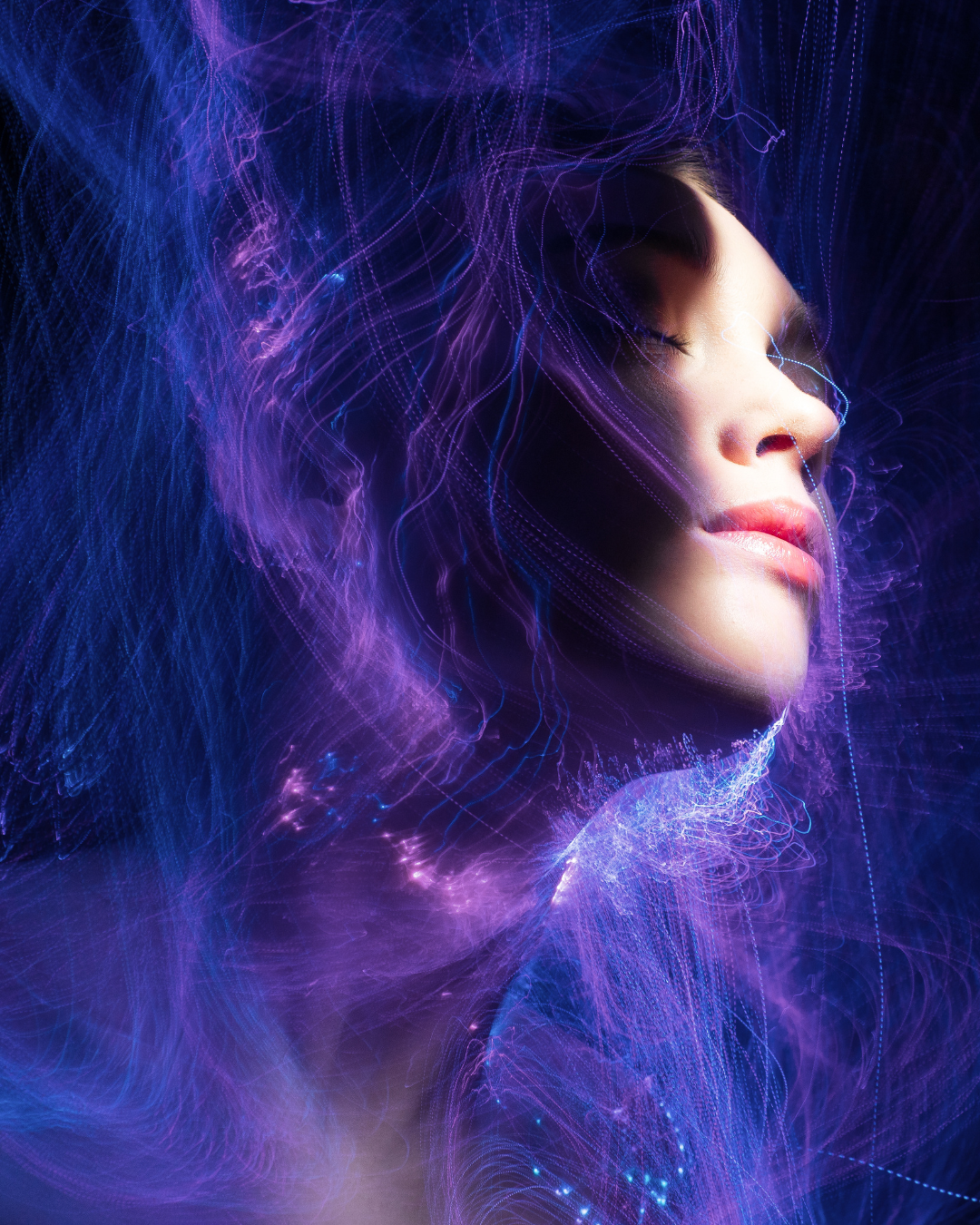 Rosto feminino iluminado com luzes azuis e roxas e efeitos etéreos