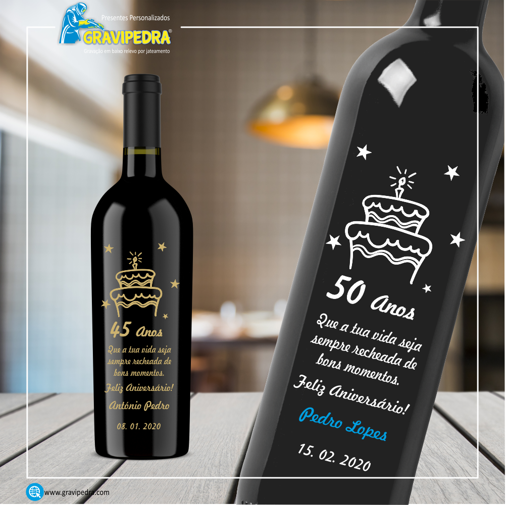 Garrafa de vinho personalizada - Aniversário - GFA17 Duas garrafas de vinho tinto personalizadas com texto e desenhos de bolos de aniversário em ambiente interior desfocado