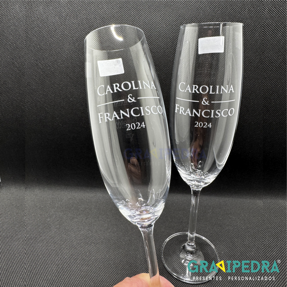 Pack 2 Copos em vidro personalizados - Nomes - CVCND10A Dois copos de vidro para champanhe com texto branco gravado e etiquetas brancas sobre fundo preto