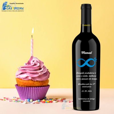 Garrafa de vinho preta com rótulo personalizado ao lado de cupcake com vela acesa