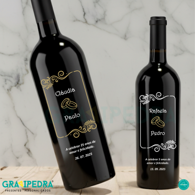 Duas garrafas de vinho tinto com rótulos personalizados e decoração com alianças entrelaçadas.