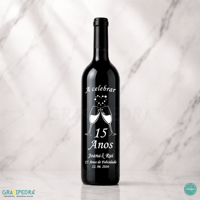 Garrafa de vinho preta com texto branco comemorativo e desenho de copos brindando.