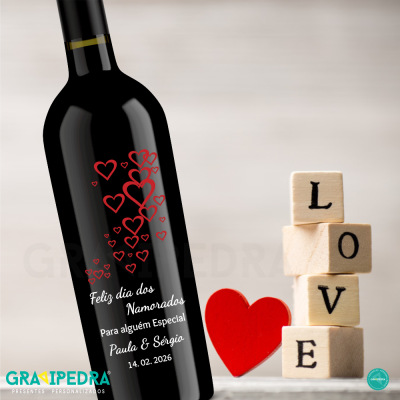Garrafa de vinho com design de corações e texto, blocos de madeira com a palavra LOVE e coração vermelho ao lado