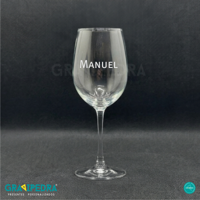 Copo de vinho transparente com a palavra MANUEL em branco