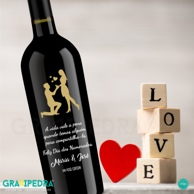 Garrafa de vinho preta com texto em português e blocos de madeira com palavra LOVE ao lado