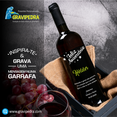 Garrafa de vinho personalizada com mensagem de feliz aniversário numa caixa com tecido juta, copo de vinho e uvas vermelhas