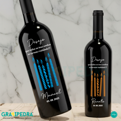 Duas garrafas de vinho tinto com rótulos personalizados em azul e laranja sobre fundo de mármore.