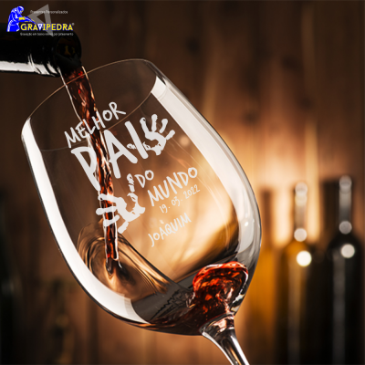 Copo de vinho com gravação 'MELHOR PAI DO MUNDO 19.03.2022 JOAQUIM' e vinho a ser servido