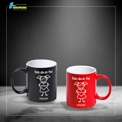 Duas canecas coloridas com mensagens de Feliz dia do Pai e datas, numa superfície cinzenta.