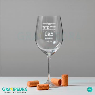 Copo de vinho personalizado com texto de aniversário e quatro rolhas de cortiça.