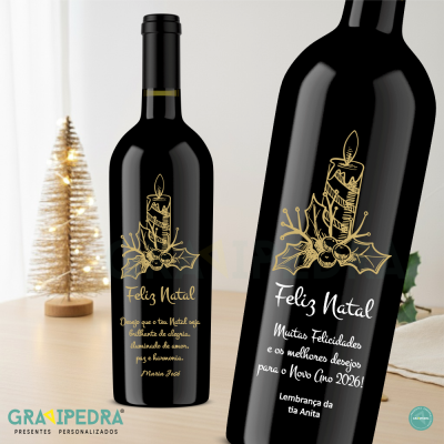 Duas garrafas de vinho decoradas para Natal com texto em português e vela dourada, com árvore de natal iluminada ao fundo