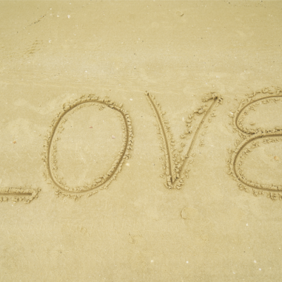 Palavra LOVE escrita na areia da praia