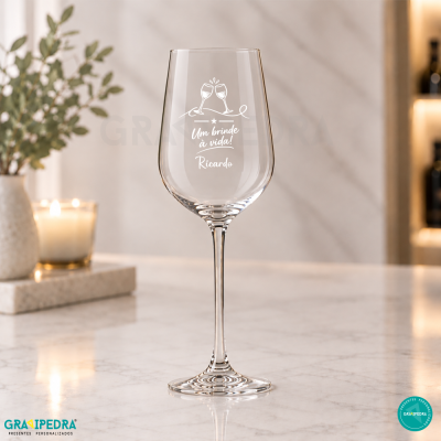 Taça de vinho transparente com inscrição branca e decoração de brindes