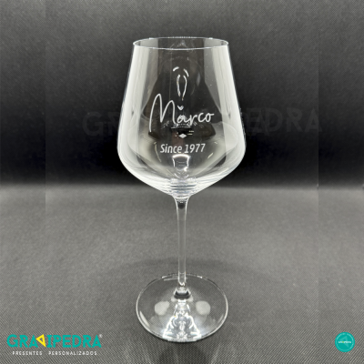 Copo de vinho em vidro transparente com texto personalizado em fundo preto