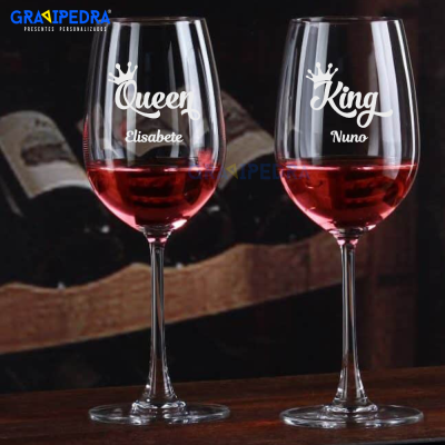 Dois copos de vinho com gravações personalizadas em branco com textos 'Queen Elisabete' e 'King Nuno'.