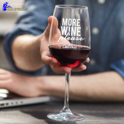 Copo de vinho com texto impresso e vinho tinto segurado por pessoa