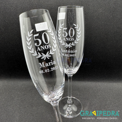 Dois copos de vidro gravados com texto comemorativo '50 ANOS Maria' e '50 ANOS António'
