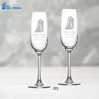 Dois copos de champanhe com gravação de casal de noivos, nomes e data de casamento.