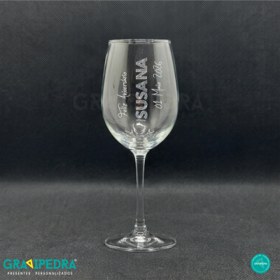 Copo de vinho transparente personalizado com texto branco em fundo cinza escuro