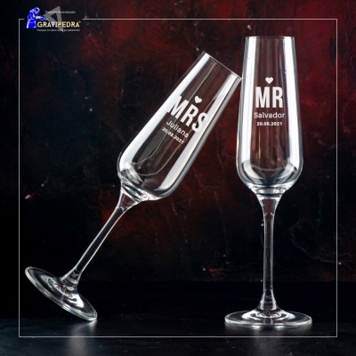 Dois copos de champanhe transparentes com inscrições personalizadas em branco