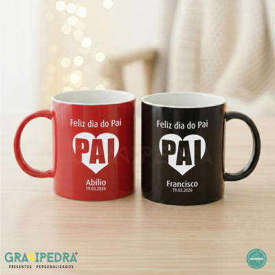 Duas canecas ceramic coloridas com texto Feliz dia do Pai e nomes Abílio e Francisco, sobre mesa de madeira.