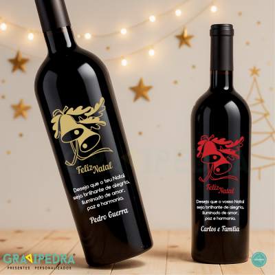 Duas garrafas de vinho com rótulos natalícios personalizados sobre mesa de madeira com luzes e estrelas douradas no fundo