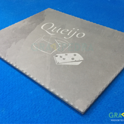 Placa de pedra cinzenta com texto 'Queijo' e desenho de queijo sobre fundo azul