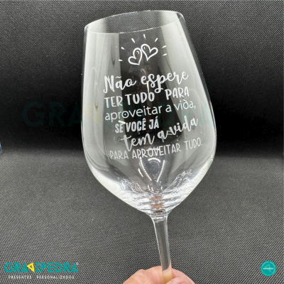 Copo de vidro transparente com texto branco decorativo e fundo preto