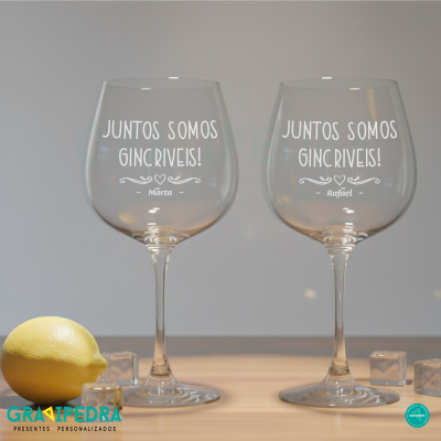 Dois copos de vinho gravados com nomes Marta e Rafael e a frase JUNTOS SOMOS GINCRIVEIS!, com limão e cubos de gelo ao lado