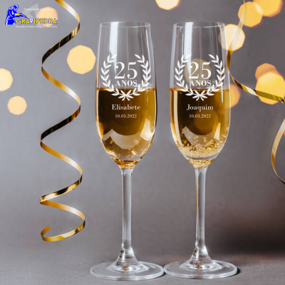 Dois copos de champanhe personalizados com gravação comemorativa e fitas douradas no fundo