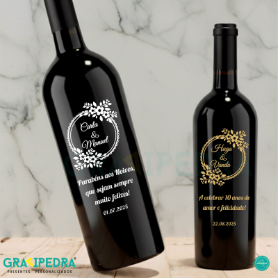 Duas garrafas de vinho personalizadas com textos e motivos florais em fundo de mármore