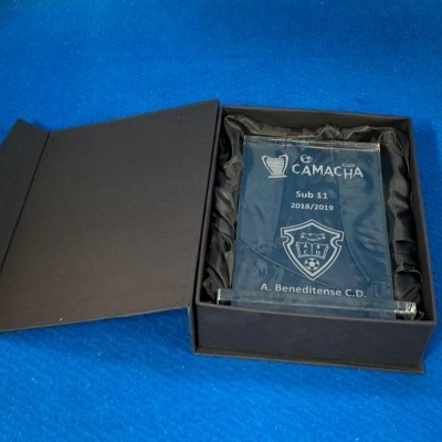 Placa de vidro azul gravada dentro de caixa preta acolchoada