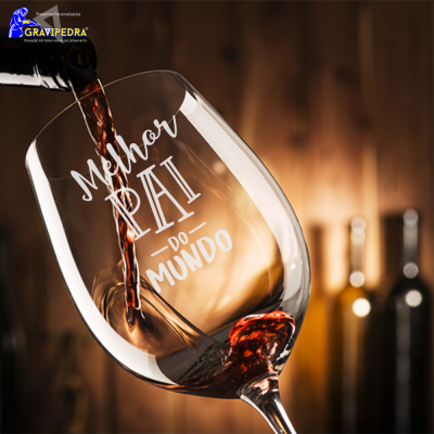 Copo de vinho com texto 'Melhor PAI do MUNDO' e vinho tinto a ser vertido.