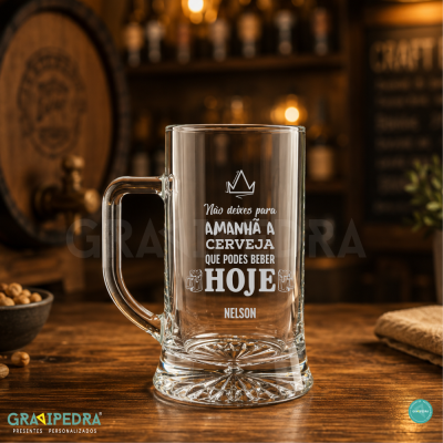 Caneca de vidro com texto gravado sobre mesa de madeira