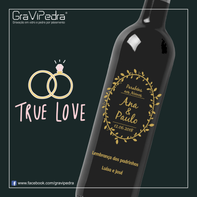 Garrafa de vinho preta gravada com texto personalizado e desenho de alianças com texto 'TRUE LOVE'.
