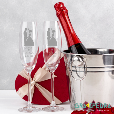 Taças de champanhe gravadas, caixa vermelha em forma de coração e balde metálico com champanhe